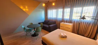 a bedroom with a bed and a table and a chair at Dragon Studio in Porto