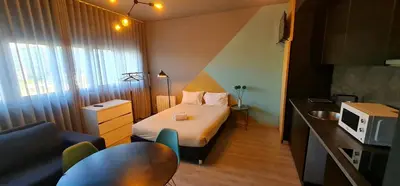 a small hotel room with a bed and a sink at Dragon Studio in Porto