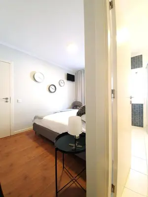 a bedroom with a bed and a table with a chair at Sonetos - Guest House in Porto