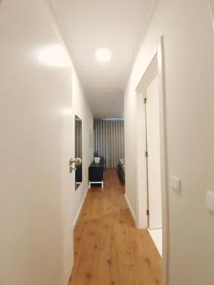a hallway of a room with white walls and wood floors at Sonetos - Guest House in Porto