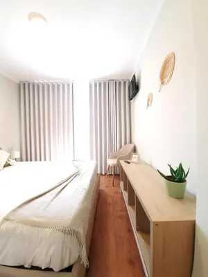 a bedroom with a large bed and a desk at Sonetos - Guest House in Porto