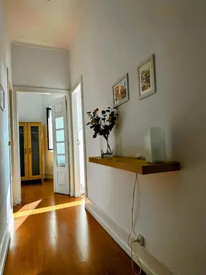 a living room with a vase of flowers on a shelf at Figueiroa 10 in Porto