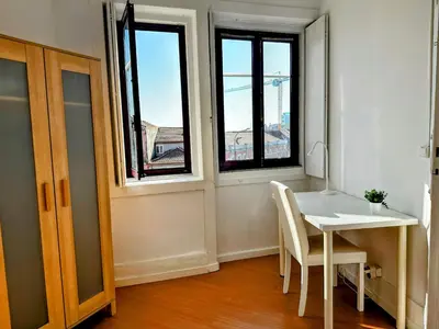 a white table and chairs in a room with windows at Figueiroa 10 in Porto