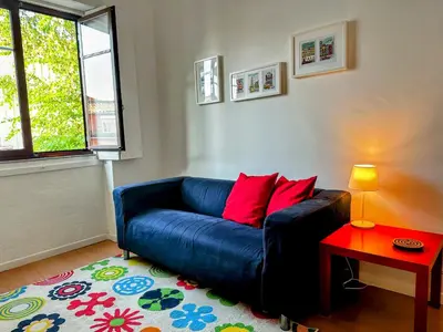 a blue couch in a living room with a table at Figueiroa 10 in Porto