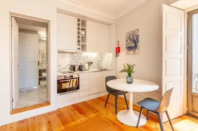 a white kitchen with a table and chairs at D&S - Palácio dos Príncipes in Porto