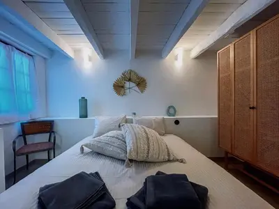 a bedroom with a large bed with two bags on it at Prédio da Estação in Porto