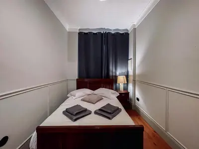 a bedroom with a bed with two pillows on it at Prédio da Estação in Porto
