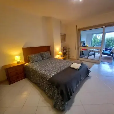 a bedroom with a large bed and a large window at Apartment with Private Garden in Porto