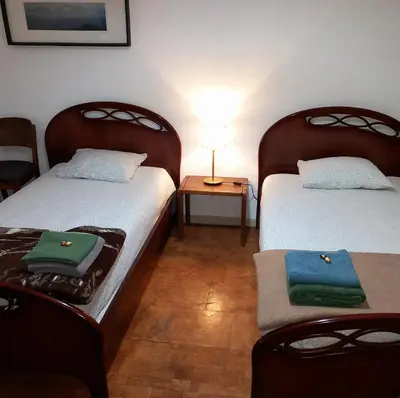 a room with two beds and a table with a lamp at Apartment with Private Garden in Porto