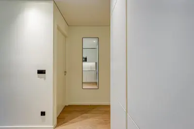 a hallway with a mirror and a white wall at Blissful Suites Porto by gaiarooms in Porto
