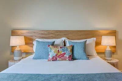 a bedroom with a white bed with pillows and two lamps at Blissful Suites Porto by gaiarooms in Porto