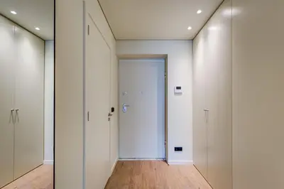 a hallway with white doors and a wooden floor at Blissful Suites Porto by gaiarooms in Porto