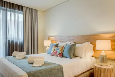 a bedroom with a large bed with two lamps at Blissful Suites Porto by gaiarooms in Porto