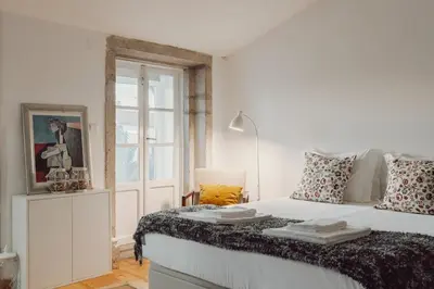 a white bedroom with a large white bed and a window at Papa Apartment with Terrace in Porto