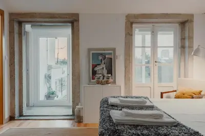 a white room with a bed and a window at Papa Apartment with Terrace in Porto