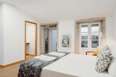 a white bedroom with a large bed and windows at Papa Apartment with Terrace in Porto