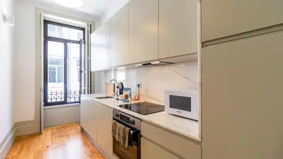 a kitchen with white cabinets and a microwave at Formosa Delight by LovelyStay in Porto