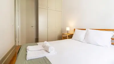 a bedroom with a white bed with towels on it at Formosa Delight by LovelyStay in Porto