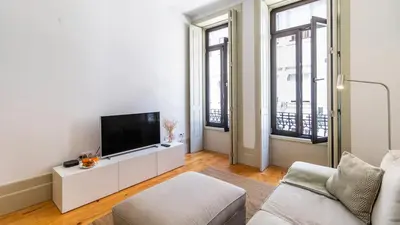 a white living room with a flat screen tv at Formosa Delight by LovelyStay in Porto
