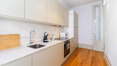 a kitchen with white appliances and a wooden floor at Formosa Delight by LovelyStay in Porto