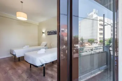 a room with two beds and a view of a building at GuestReady - October Tide in Porto