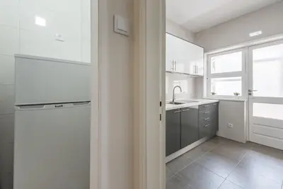 a white kitchen with a sink and a window at GuestReady - October Tide in Porto