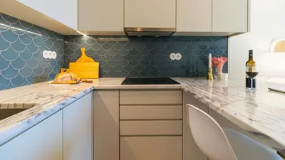 a kitchen with white cabinets and blue tiles at Downtown PortoEdition in Porto