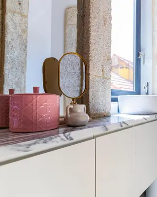a bathroom counter with a mirror and a sink at Downtown PortoEdition in Porto