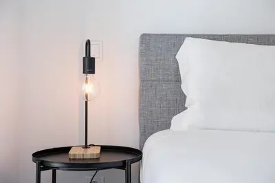 a lamp on a table next to a bed at GuestReady - Serene stay in Porto in Porto