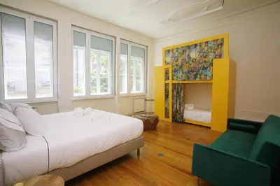 a bedroom with a bed and a couch and windows at Nº 91 - Almirante Guest House in Porto