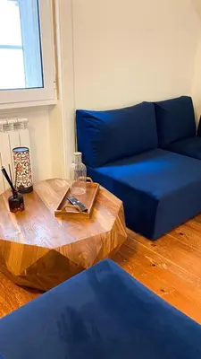 a living room with a blue couch and a wooden table at Nº 91 - Almirante Guest House in Porto