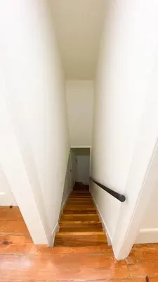 an empty room with a white wall and stairs at Nº 91 - Almirante Guest House in Porto