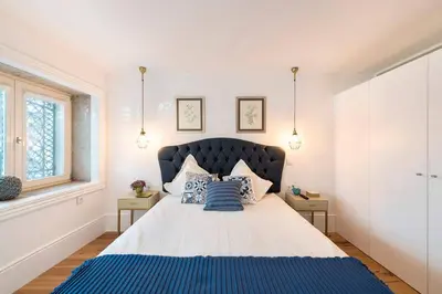 a bedroom with a large bed with blue sheets and pillows at Porto's Legacy by Upperground in Porto