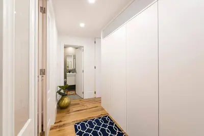 a hallway with white walls and a blue rug at Porto's Legacy by Upperground in Porto