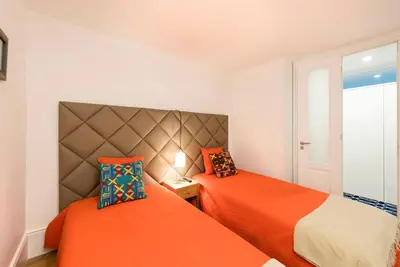 two beds in a small room with orange at Porto's Legacy by Upperground in Porto