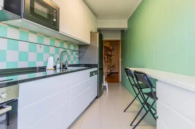 a kitchen with green and white tiles on the walls at Casa da Praça in the center of Porto - GuestSPA in Porto
