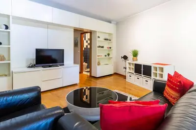a living room with a black leather couch and red pillows at Casa da Praça in the center of Porto - GuestSPA in Porto