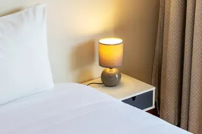 a lamp sitting on a night stand next to a bed at Casa da Praça in the center of Porto - GuestSPA in Porto