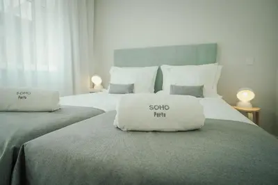 two pillows sitting on top of two beds at Soho Porto in Porto