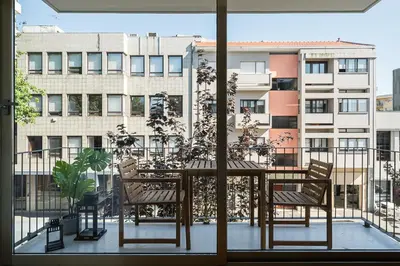 a table and chairs on a balcony with a building at GuestReady - Lux staycation in Boavista in Porto