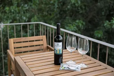 a bottle of wine sitting on a wooden table with two wine glasses at GuestReady - Lux staycation in Boavista in Porto