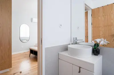 a white bathroom with a sink and a mirror at GuestReady - Lux staycation in Boavista in Porto