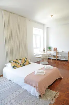 a bedroom with a bed and a table with chairs at Porto City Center Mercado do Bolhão Prime location jesuína e as 3 janelas in Porto