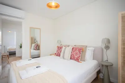 a white bedroom with a large white bed with pillows at Liiiving in Porto - Downtown Quiet House in Porto