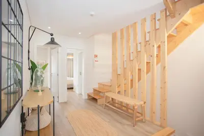 a room with a staircase with a bench and a table at Liiiving in Porto - Downtown Quiet House in Porto