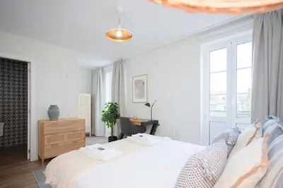 a white bedroom with a bed and a desk at Liiiving in Porto - Downtown Quiet House in Porto