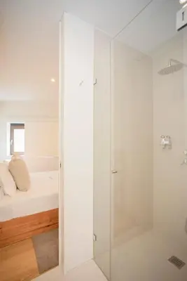 a glass shower door in a bedroom with a bed at Liiiving in Porto - Cedofeita Green Terrace in Porto