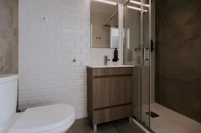 a bathroom with a toilet and a glass shower at Porto Hostel Cúpula in Porto