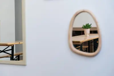 a mirror reflecting a table with a potted plant on it at Porto Hostel Cúpula in Porto
