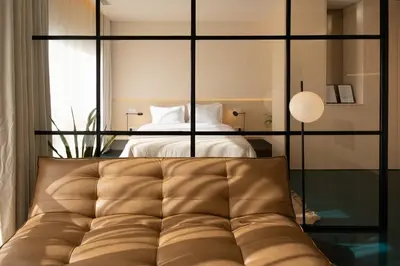 a bedroom with a bed and a couch in the foreground at Stylish Downtown Loft in Porto